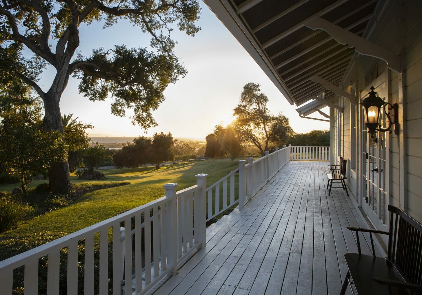 Front-porch-of-white-barn-style-home-with-green-grass-and-ocean-views
